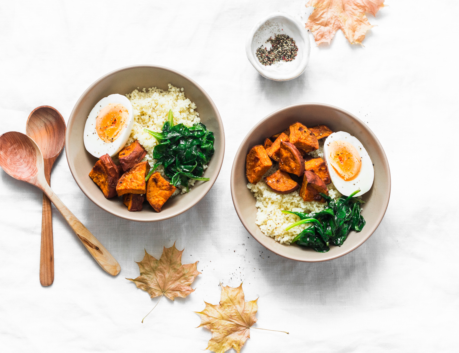 Sweet potato, couscous, spinach, egg buddha bowl on light background, top view. Vegetarian food concept